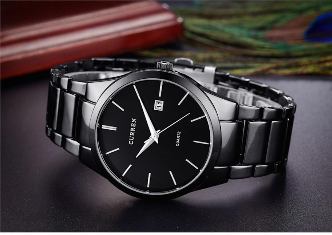 Orologio uomo Curren Elegance Black/Black sdraiato su una superficie.