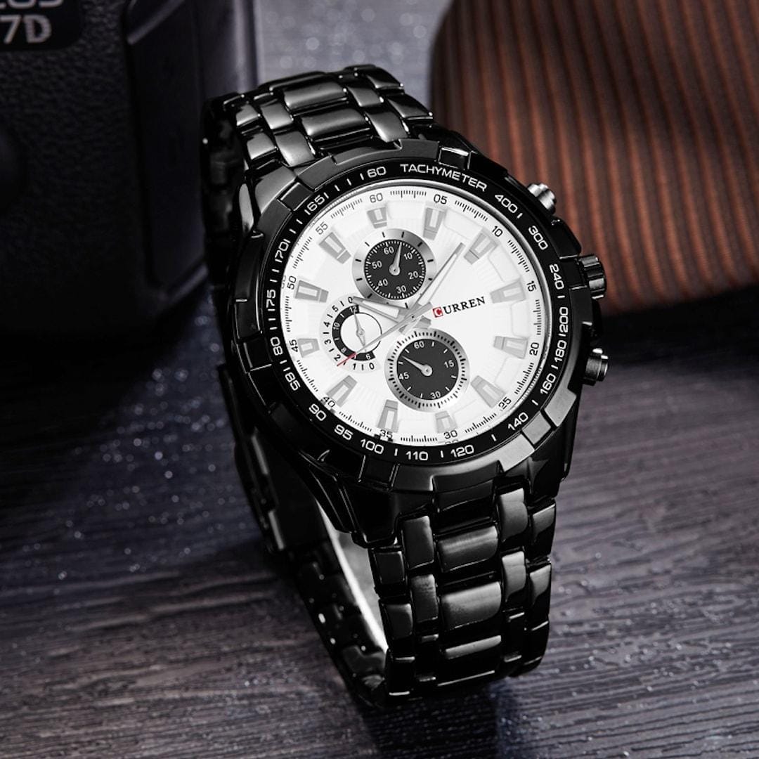 L'immagine mostra l'orologio uomo Curren Grand Prix Black/White, che si illumina elegantemente su uno sfondo scuro.