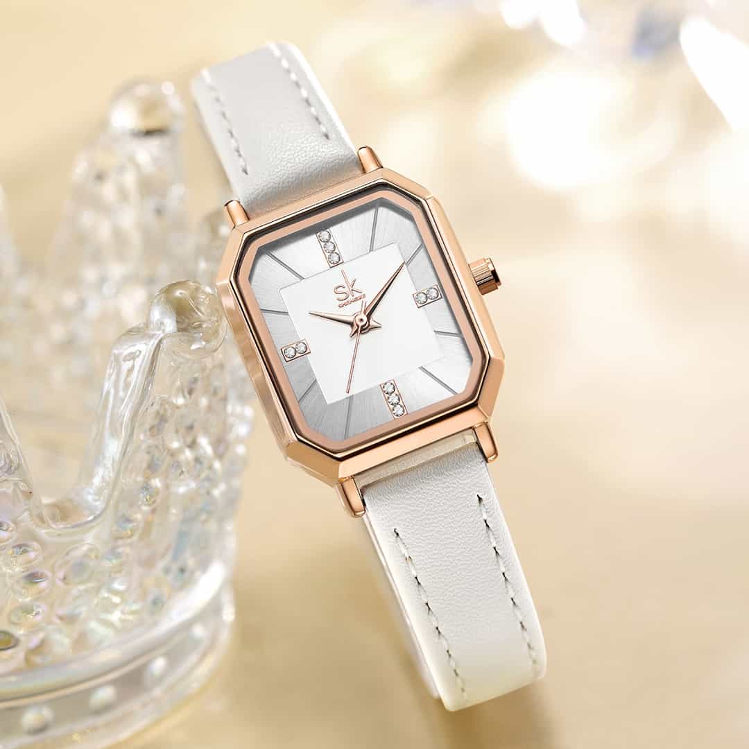 Orologio donna SK Shengke Chic White su sfondo decorativo.