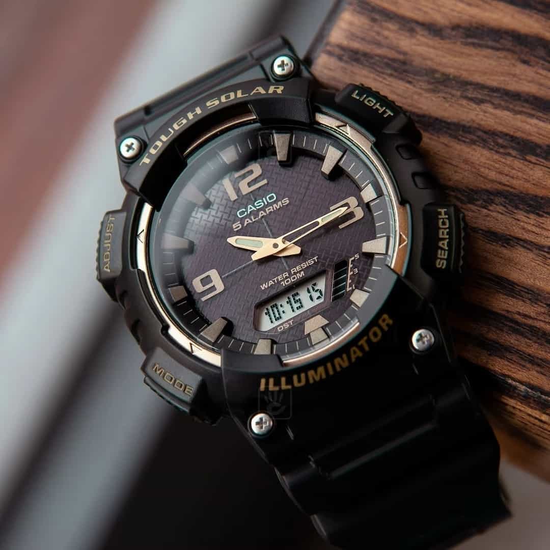 Primo piano dell’orologio da uomo Casio Tough Solar AQ-S810W-1A3VDF, che evidenzia il quadrante nero e oro e il display digitale.