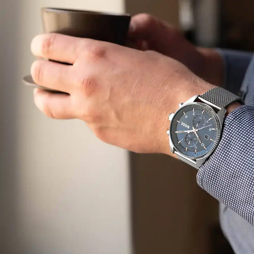 Polso maschile con orologio Hugo Boss Skytraveller 1514149 mentre tiene in mano una tazza di caffè